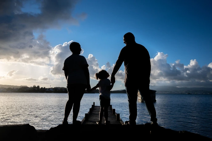 Séance photo famille en Martinique sur la plage au coucher du soleil Portrait de couple réalisé en Martinique en extérieur Photographe famille professionnelle en Martinique Photo de famille naturelle en Martinique